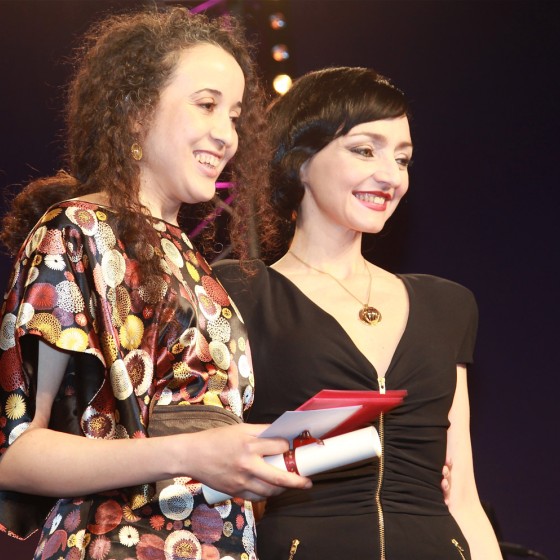 Amal Kateb reçoit le Swann d'Or du meilleur court métrage pour son film On ne mourra pas des mains de la présidente du Jury Maria de Medeiros