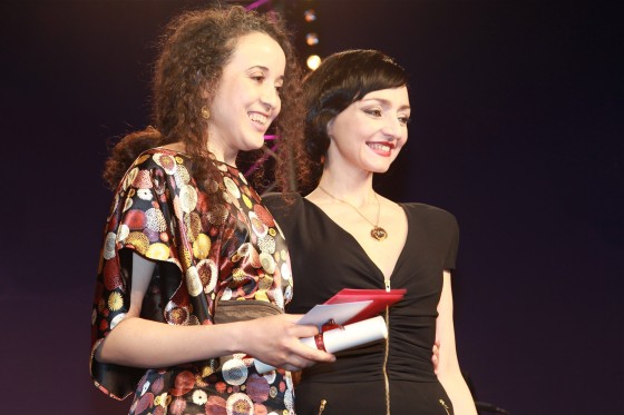 Amal Kateb reçoit le Swann d'Or du meilleur court métrage pour son film On ne mourra pas des mains de la présidente du Jury Maria de Medeiros